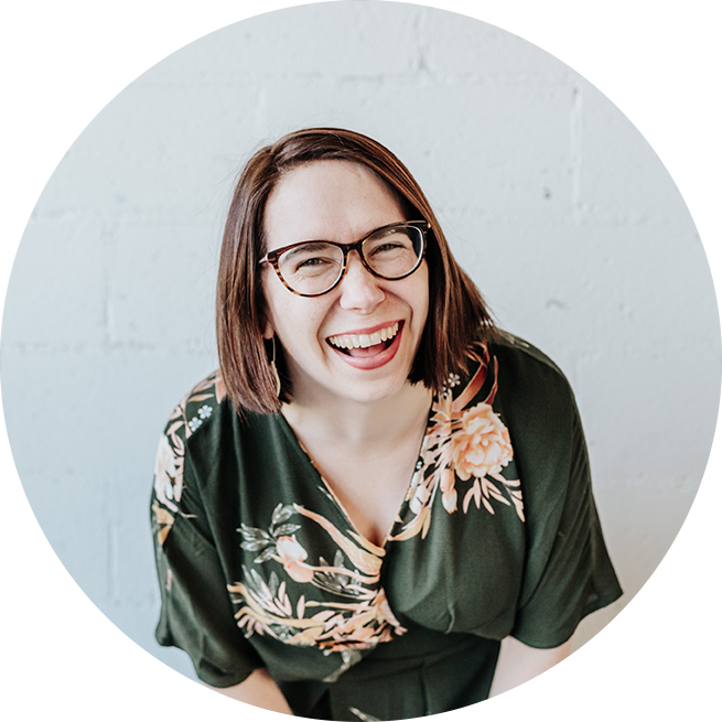 portrait of Bec Matheson Photography, image of Bec laughing at camera, she is wearing glasses and a green floral jumpsuit
