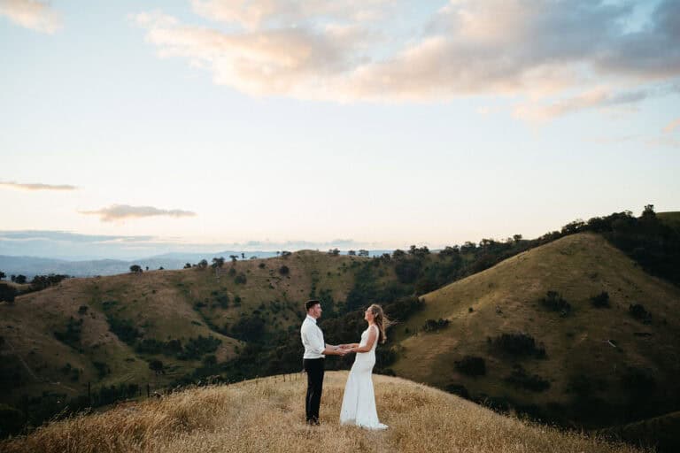 a wedding couple stand on the top of a mountain in country victoria in alexandria