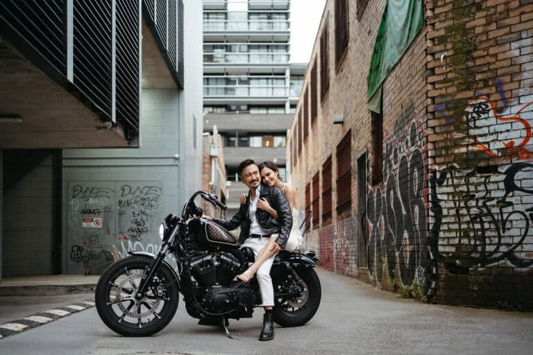 Photographer Jason Lau's wedding to musician Annette, couple sit on motorbike in a Melbourne laneway