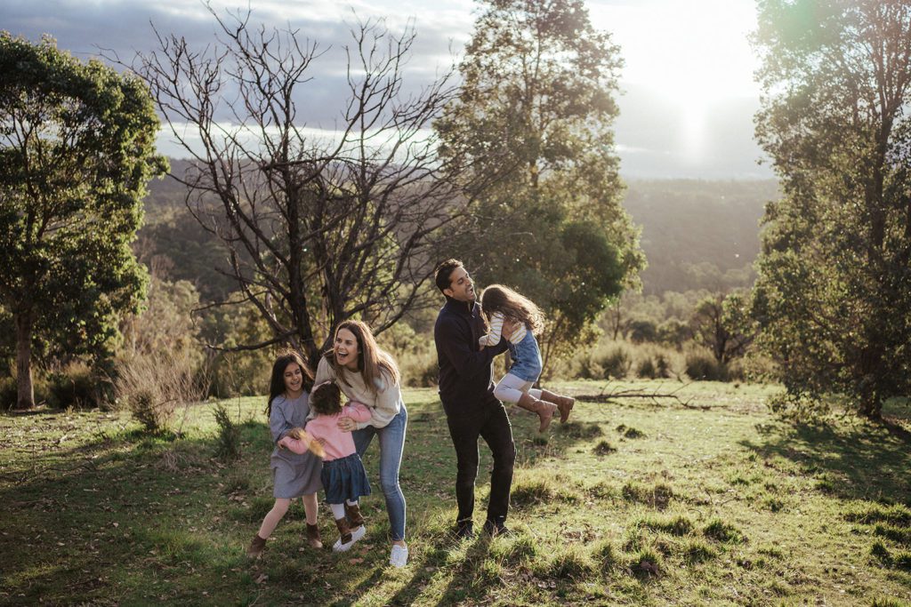 a family plays in the golden sun in the outer east of melbourne in Wonga Park