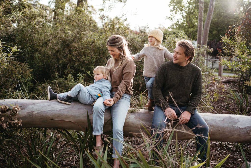 a family wearing textured knits for a photo session in brown tones with one child in a yellow beanie