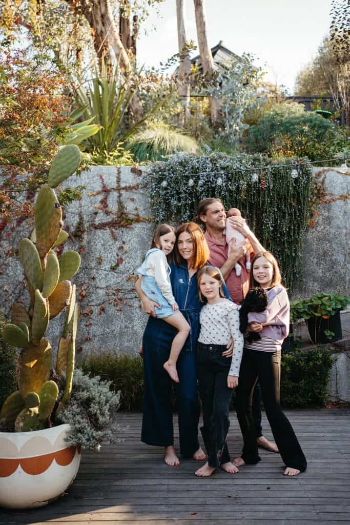 a family stand closely together on a deck