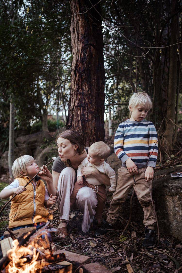 Melbourne family photographer - photos can look like a mother eating a marshmallow with her sons in front of a campfire
