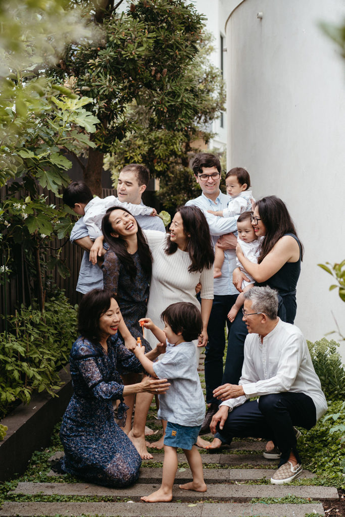 a family group photo that feels chaotic and joyful people are hugging and playing 