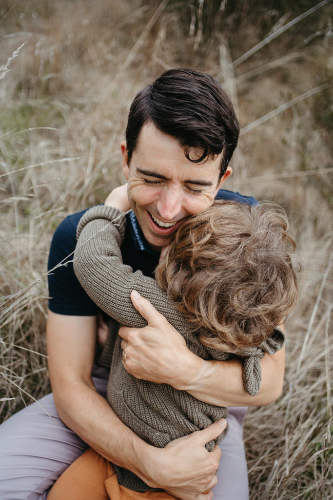 a dad closes his eyes and hugs his child with joy he is relaxed and happy