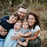 a Melbourne family look at the camera they are cuddling closely