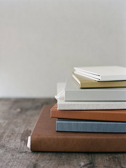 a stack of printed photo albums with different cover options in neutral tones