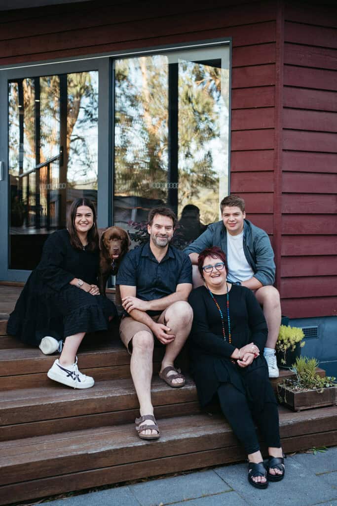 a family with teenage kids sitting on steps
