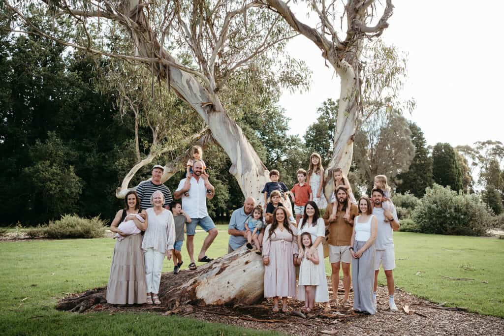 large family group infront of a big tree