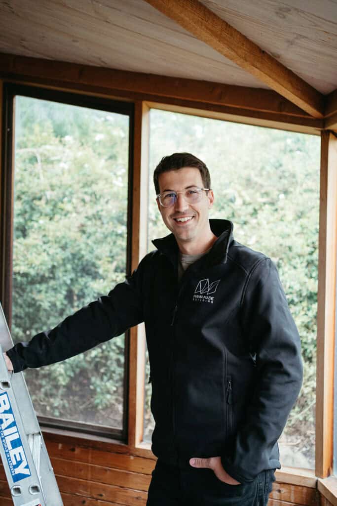 a portrait of a builder who stands next to a ladder