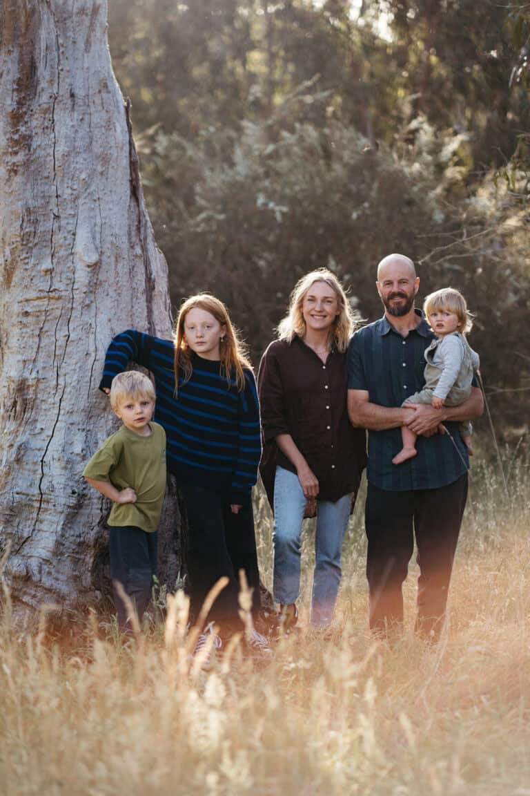 a melbourne family of five stand in a field next to a gumtree