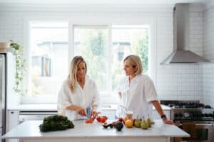 Two women chop vegetables in a Melbourne kitchen