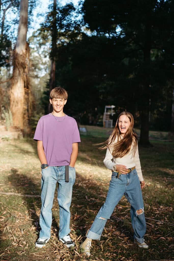 two siblings have fun together the boy wears a purple shirt, they are in high contrast light