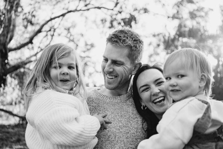 Photo of a Melbourne family laughing naturally together in the bushland the image is black and white