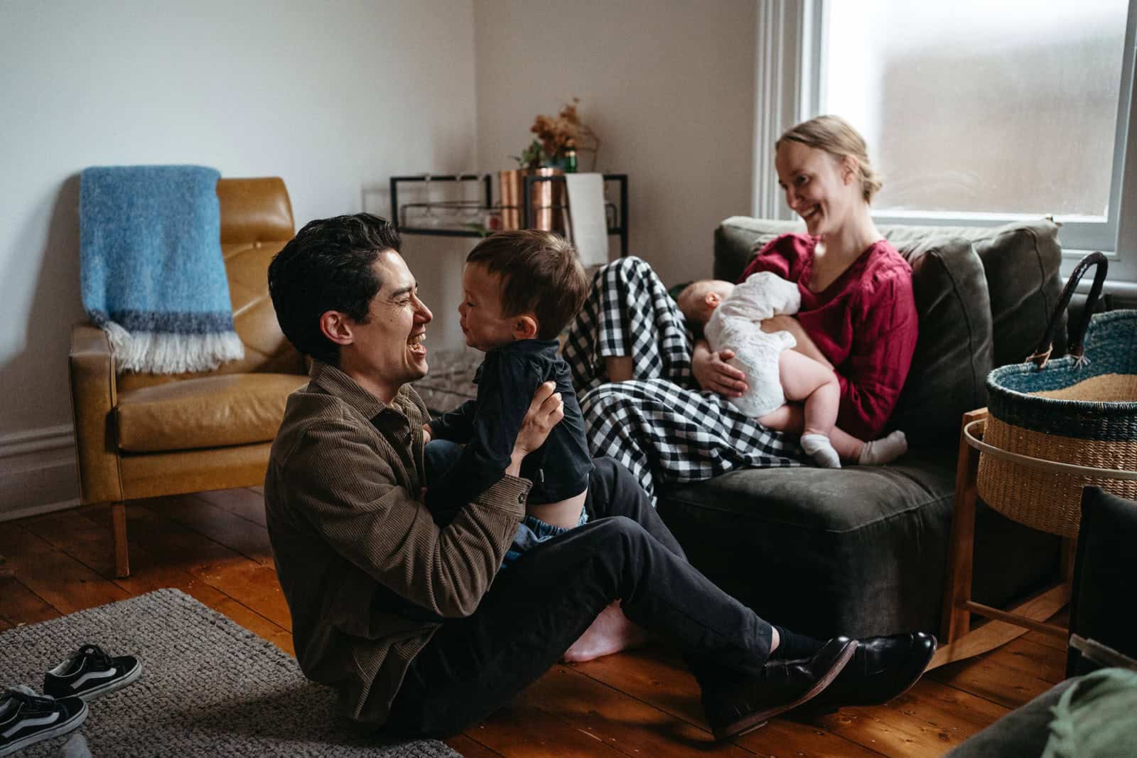 family play together dad has toddler on his knees