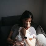 a mother holds her baby close in the sunshine