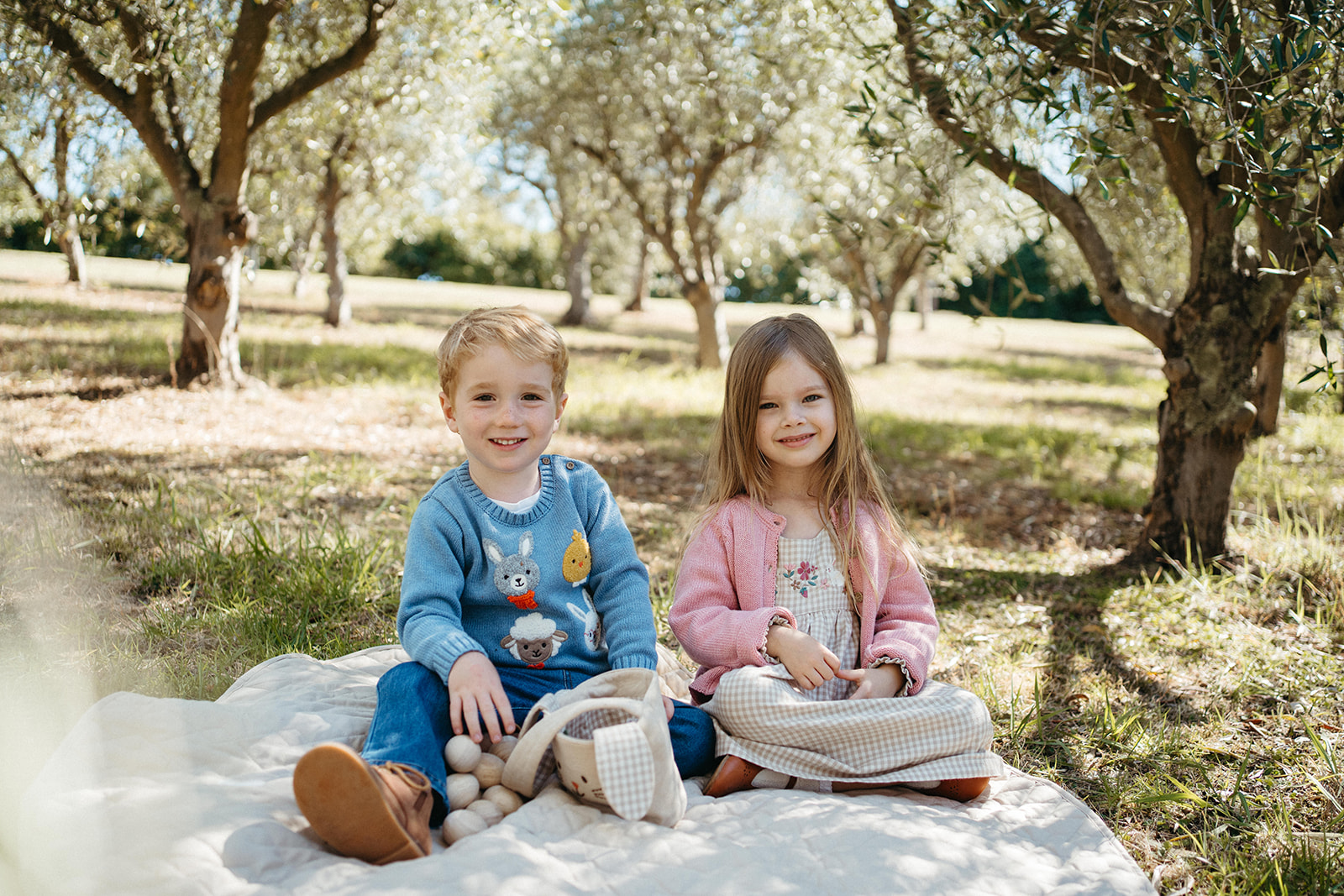 two children sitting on a picnic blanket wearing purebaby brand clothing at a photoshoot in Melbourne with Bec Matheson Photography