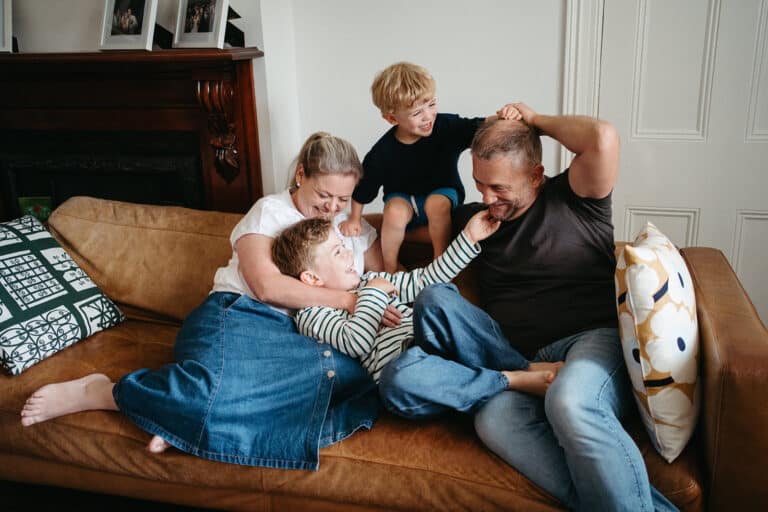 a family play on a couch at home at a natural in home family photography session in Melbourne