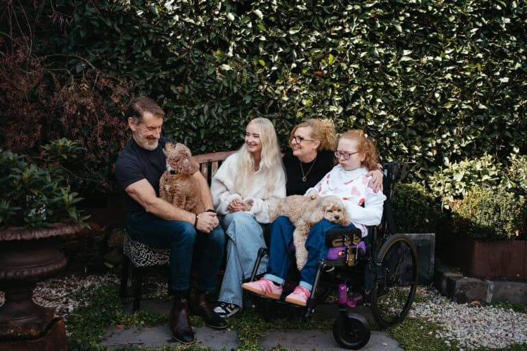 family of four with a dog, one child is in a wheelchair