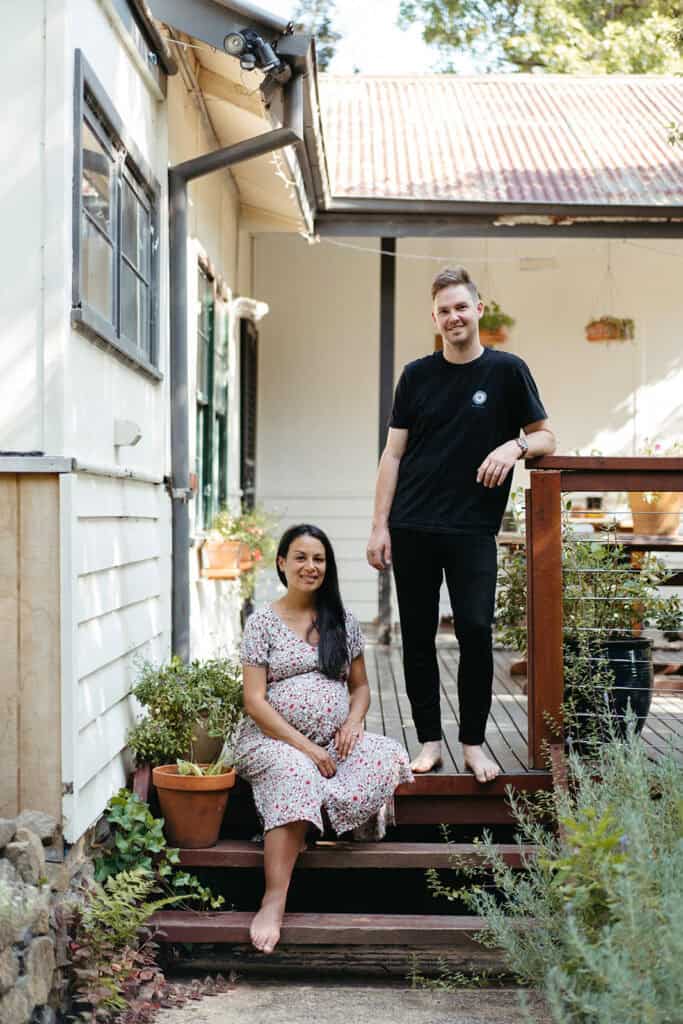 Pregnancy couple on porch in Melbourne the woman is sitting