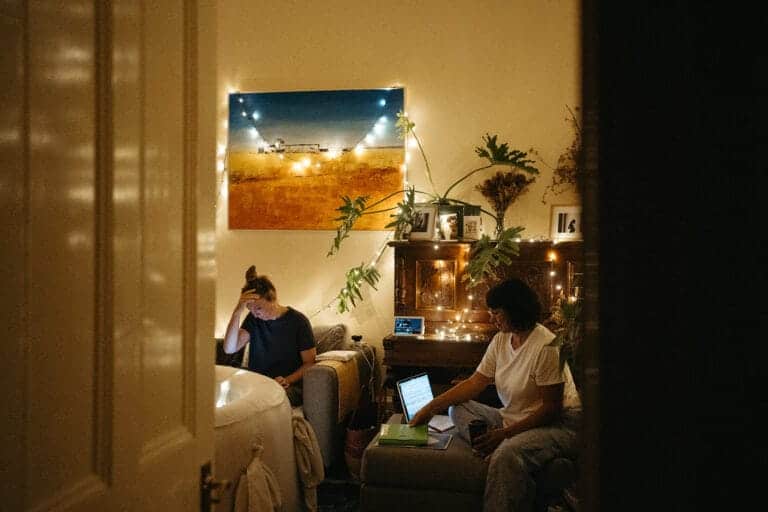 two midwives wait at a homebirth in a room with fairylights