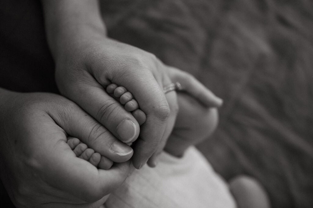 baby toes peeking out from mothers hands