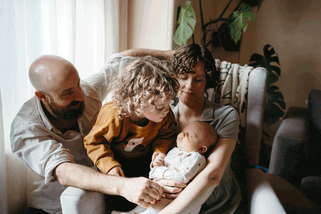 melbourne newborn photography session where a toddler is kissing the baby in a home in Malvern