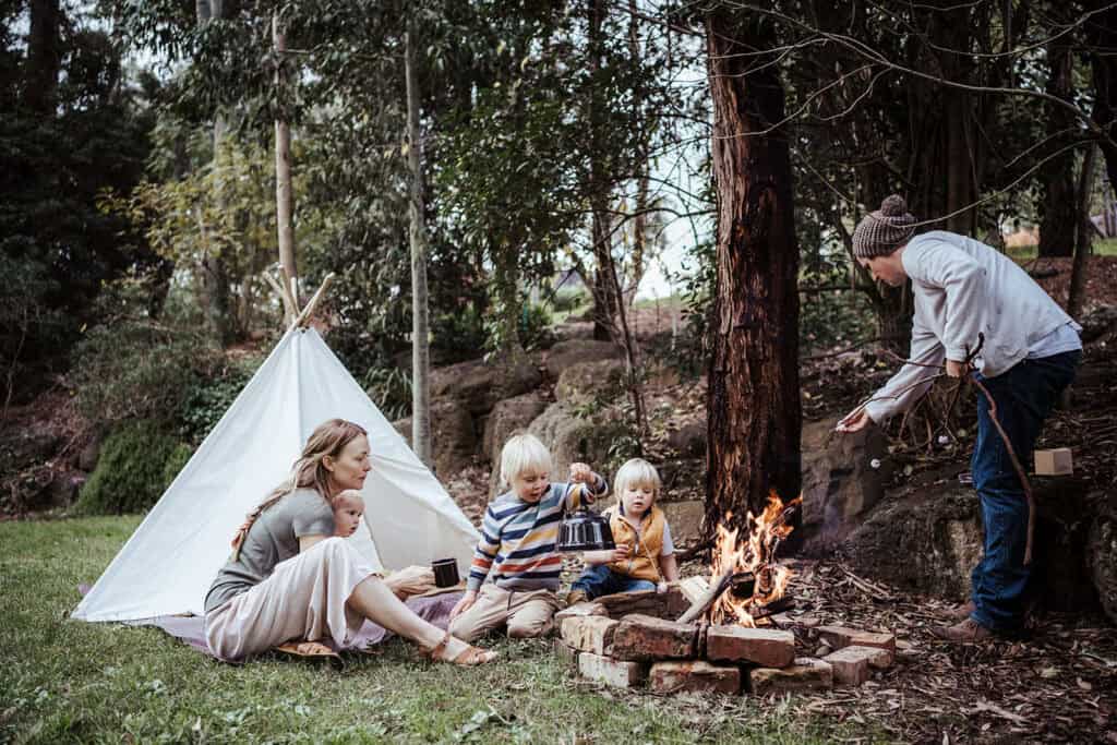 a family cook marshmallows around a fire in their yard