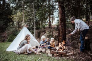 a family cook marshmallows around a fire in their yard
