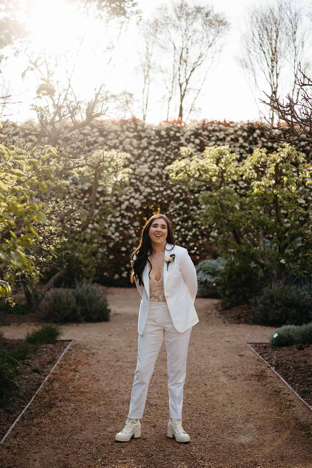 bride in a custom Isadora Nim white suit with lace bodysuit underneath 