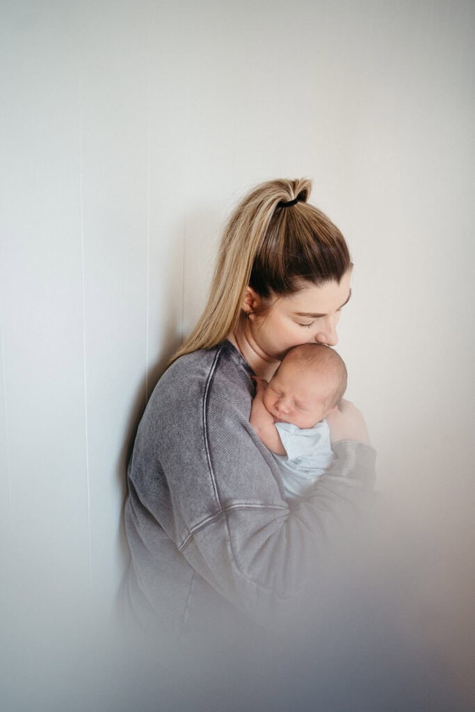 a soft image of a mother cuddling her newborn baby
