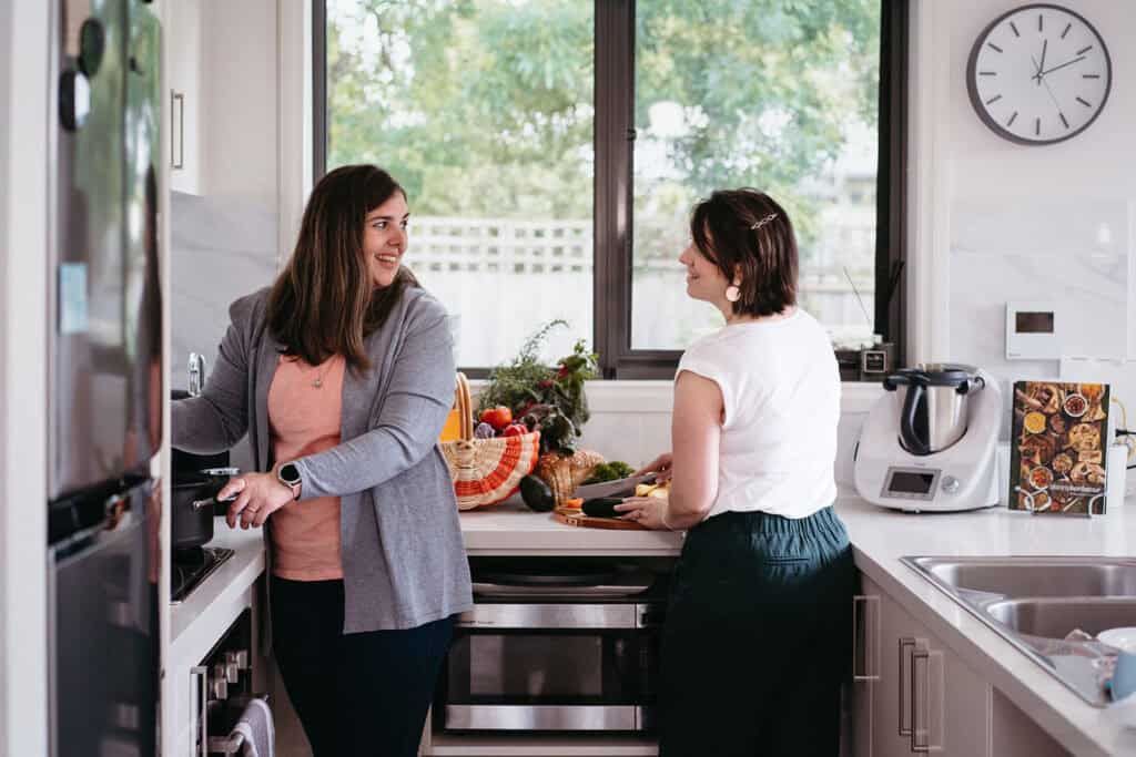 two women who are doulas prepare food in a kitchen