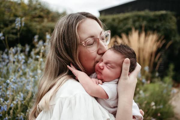 safe newborn photographer Melbourne parent holding baby during in-home session