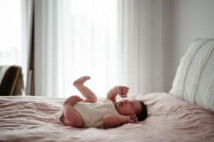 natural newborn photography Melbourne baby lying on bed at home