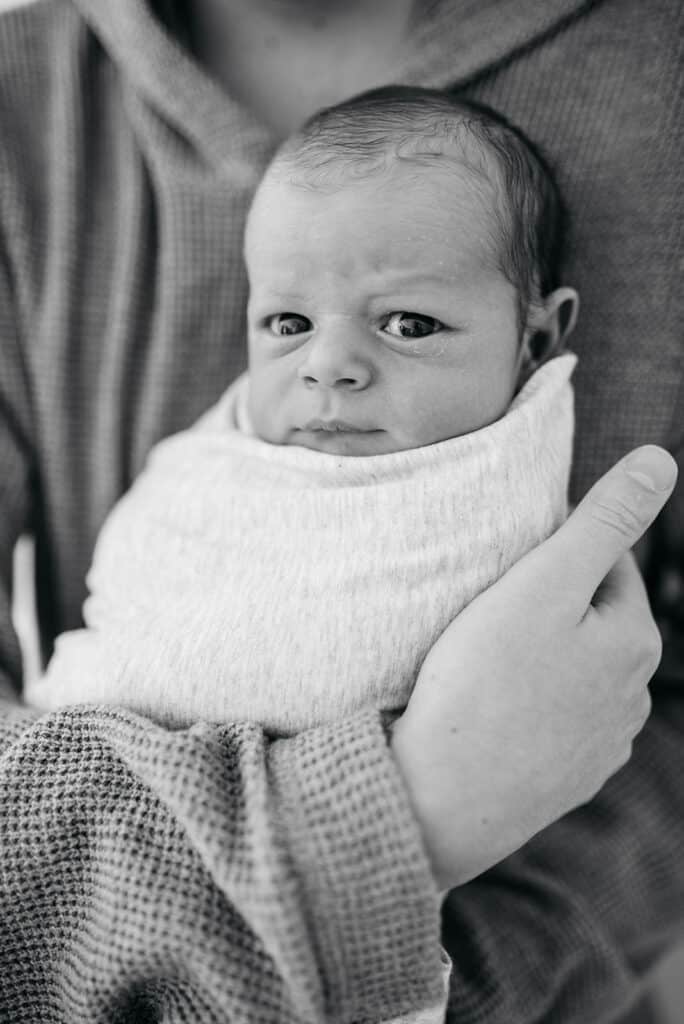 new baby with wide open eyes in black and white