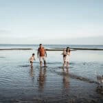 family in the water at beaumaris lifesaving club beach near ricketts point