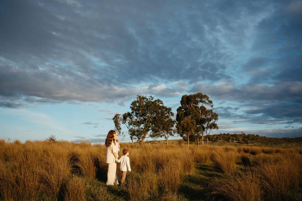 mother and children stand in a field in mernda